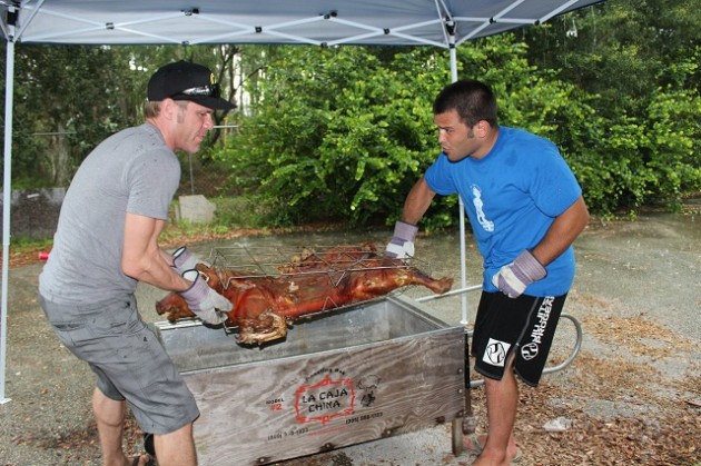 Master Roberto and Chef Jeff take the pig out of La Caja China to check it its ready.